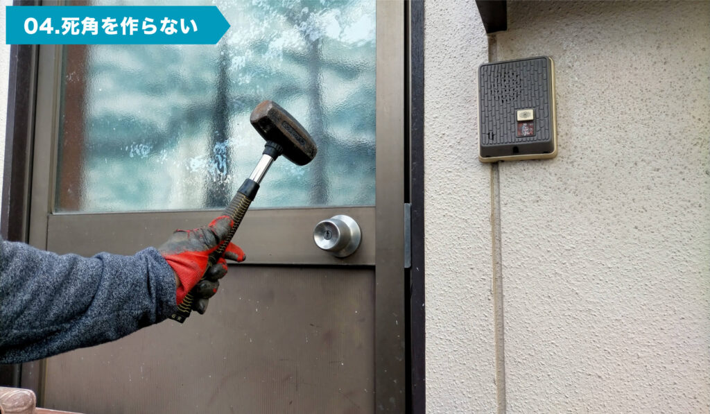 ドアをトンカチで開けようとする様子